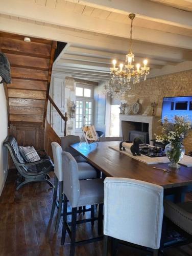 une salle à manger avec une table et des chaises et une cheminée dans l'établissement La Cour Blanche, à Verteuil-sur-Charente
