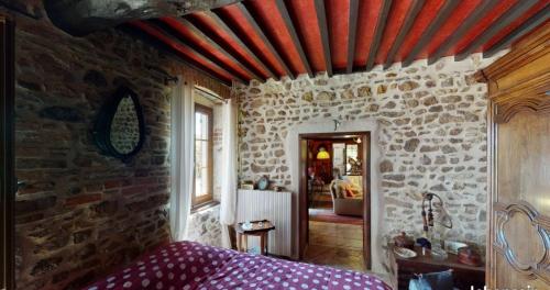 ein Schlafzimmer mit einer Steinmauer und einem Bett darin in der Unterkunft Chambre au calme de la campagne in Le Vernet