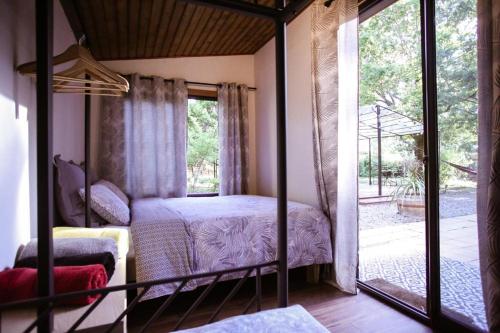 Schlafzimmer mit einem Bett und einer Glasschiebetür in der Unterkunft Grande Maison Pleine Nature 5 Chambres pour 10 à 15 pers - Surf Camp in Lacanau