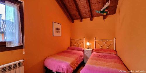 2 Betten in einem Zimmer mit orangefarbenen Wänden in der Unterkunft Casa Vacacional El Alberu in La Borbolla
