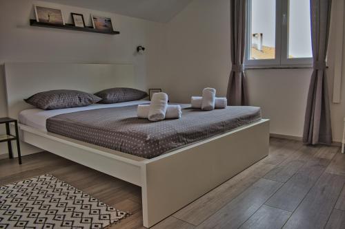 a bedroom with a bed with two towels on it at Apartments and Rooms B&B in Zadar