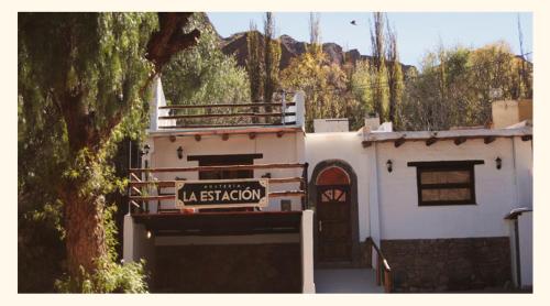 una casa blanca con un cartel delante en Hosteria La Estacion en Tilcara