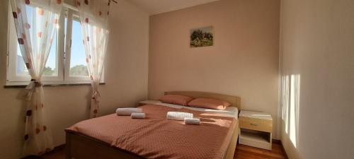 ein Schlafzimmer mit einem Bett mit zwei Handtüchern darauf in der Unterkunft Apartment Mani - modern in Ližnjan