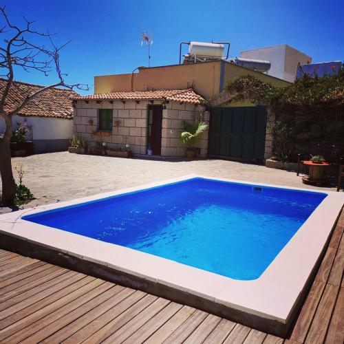 uma piscina azul em frente a uma casa em Villa los gavilanes em Santa Cruz de Tenerife