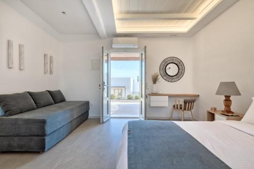 a bedroom with a bed and a couch and a table at Elia Mykonos Resort in Elia Beach