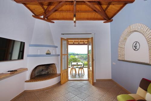 ein Wohnzimmer mit einem Kamin und einer Terrasse in der Unterkunft PETRINO in Alonnisos Altstadt