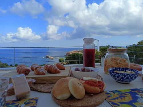 a table with food and a view of the ocean at Zabbàra B&B in Terrasini
