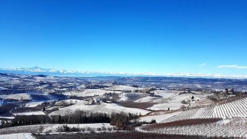 a view of a snow covered hill with houses and mountains at Villa Bellavista Alba, B&B in Alba