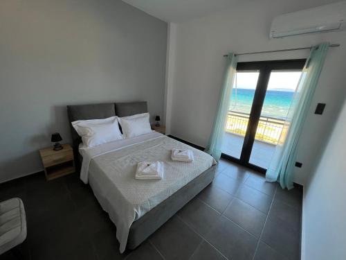 a bedroom with a bed with a view of the ocean at MEDORA By the Sea Near Airport in Artemida