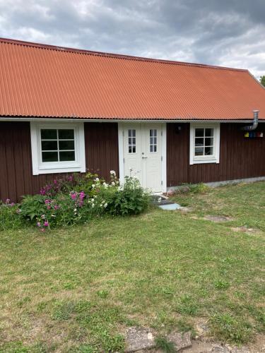 a house with a red roof and a yard at Ankiborg Bed and Breakfast in Färjestaden