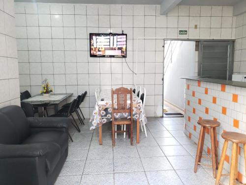a dining room with a table and chairs and a kitchen at Pousada São Francisco in Cuiabá