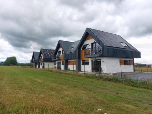 a row of houses with solar panels on them at 285 Apartments in Czarny Dunajec