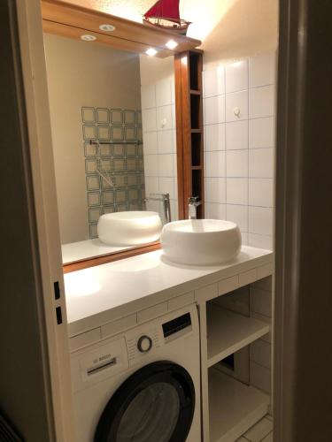 une salle de bain avec une machine à laver et un lavabo dans l'établissement C213 Appartement Vue Mer Terrasse, Parking, à Arcachon