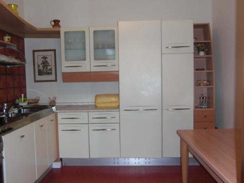 a white kitchen with white cabinets and a counter at Casa Vista Lago 154 SQM in Passignano sul Trasimeno