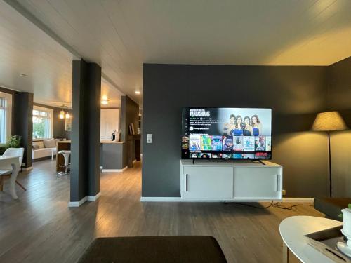 a living room with a flat screen tv on a wall at Lovely Penthouse downtown with 3 bedrooms in Akureyri