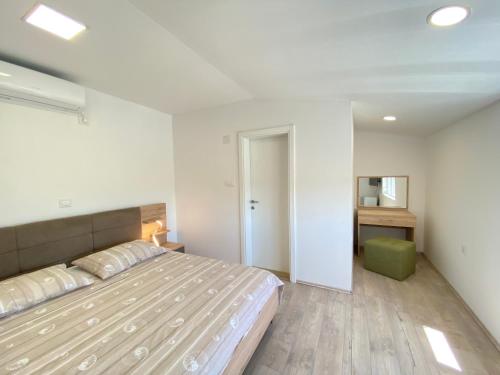 ein Schlafzimmer mit einem großen Bett und einem Schreibtisch in der Unterkunft Guest Accommodation Grozdanić in Dubravice