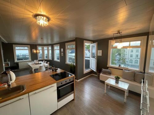 a kitchen and living room with a couch and a table at Lovely Penthouse downtown with 3 bedrooms in Akureyri