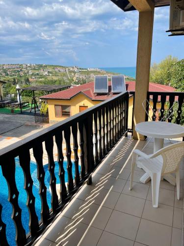 een balkon met een tafel en stoelen en uitzicht op de oceaan bij Complex Terazini in Byala
