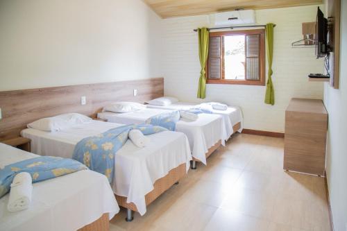 a group of four beds in a room at Pousada dos Guias in Alto Paraíso de Goiás