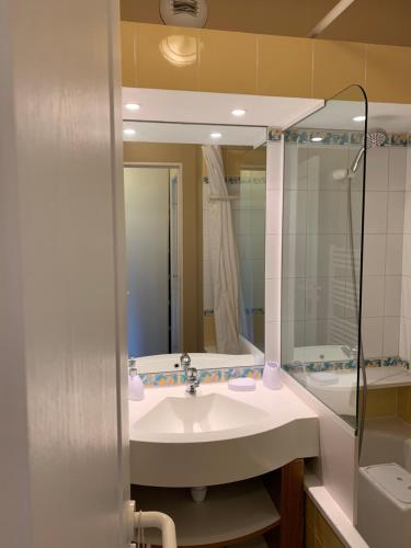 莫爾濟訥的住宿－Avoriaz - Portes du Soleil : Aux pieds des pistes，浴室配有盥洗盆、镜子和浴缸