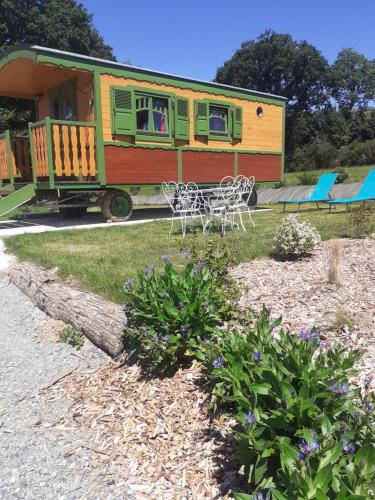d'une table et de chaises dans la cour dans l'établissement La roulotte de kermorzu, à Saint-Adrien