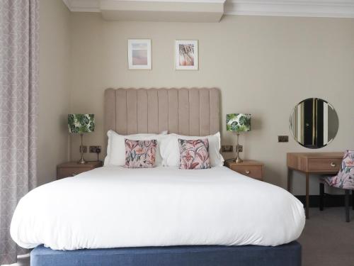 a bed with a white comforter and pillows at Hotel Collingwood BW Signature Collection in Bournemouth