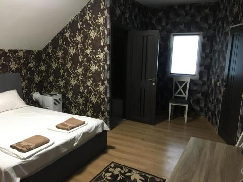 a bedroom with a bed and a table and a window at Готель Максим Ресторан in Drogovyzhe