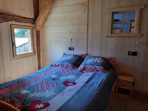 ein Schlafzimmer mit einem Bett in einer Holzhütte in der Unterkunft Chalet la corne du chamois in Sixt
