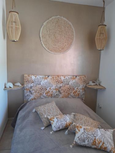 łóżko z poduszkami w sypialni w obiekcie Appartement T1 plain pied w mieście Le Cannet-des-Maures