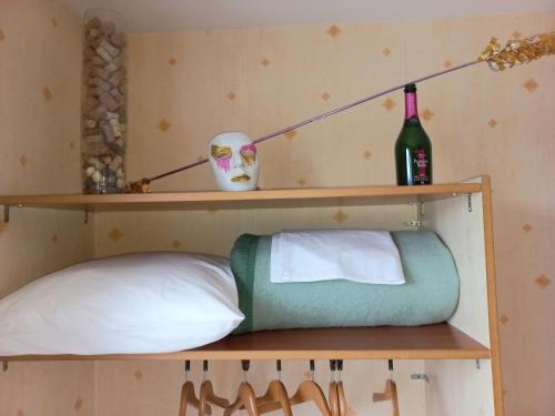 - une étagère avec un oreiller et une bouteille de vin dans l'établissement La Limouxine - Mauzac, à Limoux