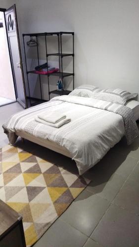 - un lit dans une chambre avec un tapis dans l'établissement Alsace N°4, au Mans