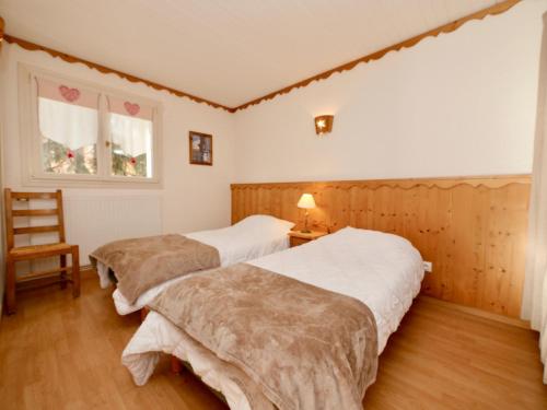 une chambre avec deux lits et une chaise et une fenêtre dans l'établissement Crocus N3, à Huez