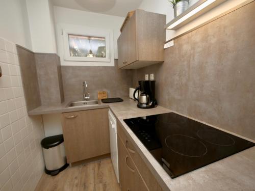 une petite cuisine avec un évier et une cuisinière dans l'établissement Crocus N3, à Huez