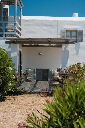 a white house with a porch and a balcony at Soros Beach Antiparos in Agios Georgios