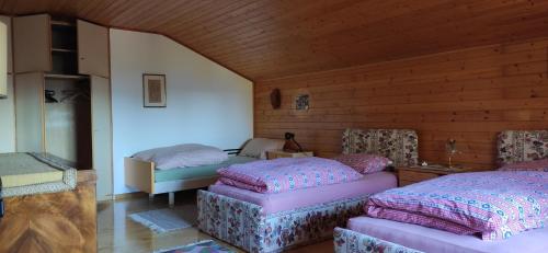 a bedroom with two beds in a room with wooden walls at Villa for a get away in Soprabolzano