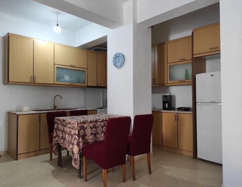 y cocina con mesa, sillas y nevera. en Sweet Apartment en Sarandë