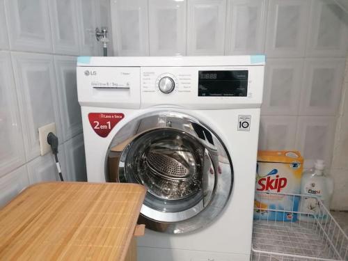 a washing machine in a kitchen with a wooden table at Cantinho dos Montes in Vila Real