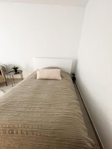 łóżko w pokoju z białą ścianą w obiekcie Schöne Einzimmerwohnung w mieście Bad Nauheim
