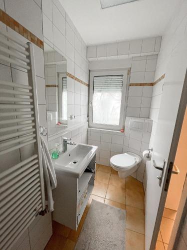 Baño blanco con lavabo y aseo en Schöne Einzimmerwohnung en Bad Nauheim