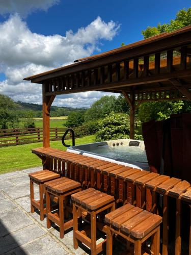 a wooden deck with benches and a swimming pool at Cwmgwn Farm in Llandovery