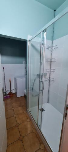 uma cabina de duche em vidro na casa de banho com piso em azulejo em Mazamet : Résidence du Musée centre ville. em Mazamet