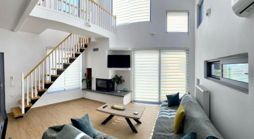 a living room with a couch and a staircase at Loft House Zante in Argassi