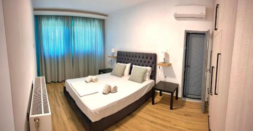 a bedroom with a large white bed and a window at Loft House Zante in Argassi