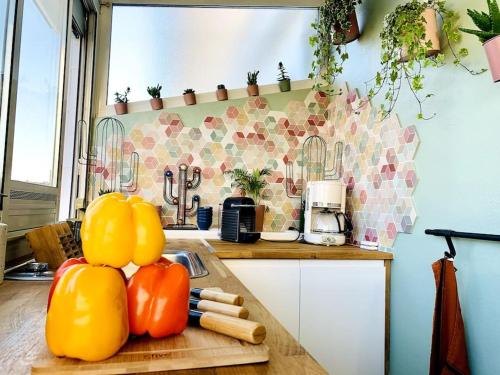 una cocina con una barra con algunas verduras en una tabla de cortar en L'Étoile Des Sables - Maison de ville climatisée classée 4 étoiles - 4 personnes - Plage de la Grande Conche à 200m - ROYAN en Royan