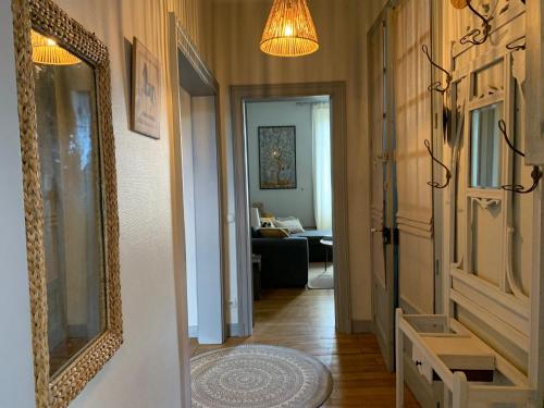 un couloir avec une porte et un miroir ainsi qu'un salon dans l'établissement La Terrasse de Compostelle T3 Chic, Charme, Cosy, à Saint-Léonard-de-Noblat