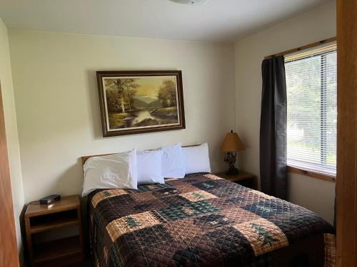 um quarto com uma cama e uma fotografia na parede em Chalet em Hill City