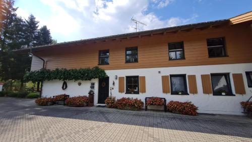 een gebouw met banken en bloemen ervoor bij Ferienwohnung Landhausliebe in Zwiesel