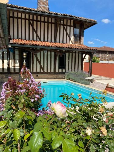 una piscina frente a una casa con flores en La Chantourelle 