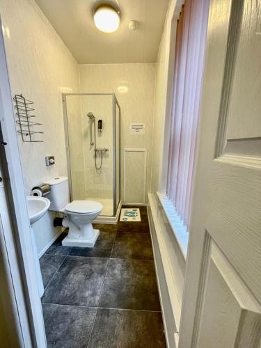 a bathroom with a toilet and a sink and a shower at Hayward Hotel in Blackpool