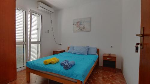 a bedroom with a bed with two towels on it at Matovic Apartments in Dobra Voda